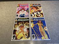 Photo showing the four Firestar comic books, numbered 1 to 4, laid out in two rows on a gray surface, each in protective bags with acid-free boards.