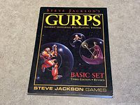 Front cover of GURPS Basic Set Third Edition Revised book showing title, author, and publisher details.