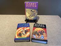 Front view of three Harry Potter hardcover books in the series, showing colorful dust jackets with artwork corresponding to each book's theme.