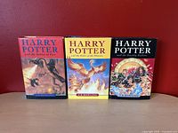 Front covers of three Harry Potter hardcover books showing colorful illustrations for each title.