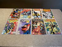 Eight Marvel comic books from the 1990s neatly arranged on a table. Covers include characters like Thor, Cable, and Punisher among others.
