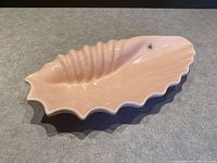 Top view of the pink ceramic shell-shaped candy dish showing ridged texture and glossy finish.