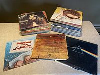 Stacks of record albums showing well-known album covers Pink Floyd Dark Side of the Moon, Cheech & Chong Up in Smoke, and others to illustrate content and condition.