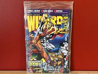 Front cover of sealed Wizard magazine issue 23 showing colorful comic book characters and magazine title details.