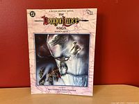 Front cover of The Dragonlance Saga Book Four graphic novel showing the illustrated fantasy scene with characters and dragon.