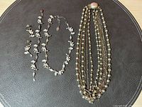 Photo showing the full set: vintage multi-strand necklace with faux pearls, gold-tone spacers, and a large decorative clasp with a pink cabochon, alongside the Claire's matching floral vine jewelry set (necklace, bracelet, earrings) with pastel beads.