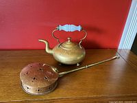 Set includes vintage brass kettle with white milkglass handle and copper brass bed warmer with perforated lid and long handle.