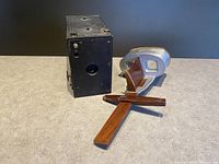 Vintage Kodak Brownie box camera and Underwood stereoscope viewed together on a surface
