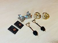 Four pairs of vintage clip-on earrings displayed on a light surface showing details of designs and materials