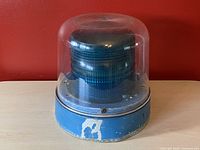 Front view of the vintage signalling beacon showing blue base and clear dome with blue lens inside