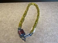 Full view of the vintage Yung Fang bike lock chain showing yellow plastic covered chain and combination lock at one end.
