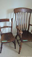 Two vintage wooden chairs side by side showing size difference and style details.