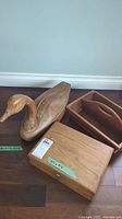 Full view of wooden duck sculpture alongside two wooden boxes.