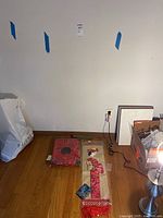 Wide view of Asian themed items including wall hanging, floral pouch, chopstick holder, and cosmetic bags on floor near wall.