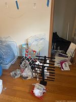 Photo of two black jewelry display racks with various earrings and necklaces tagged and on cards, with loose jewelry pieces in bags around; some sterling jewelry visible