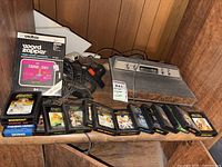 Photo showing Atari 637-75005 console, two joystick controllers, and multiple game cartridges including boxed 'Word Zapper' cartridge.