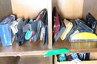Photo of wallets and small bags arranged in cubby storage showing various wallets including boxed Quick Card wallet and several compact wallets.