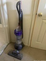 Front view of upright vacuum showing dust bin and floor head