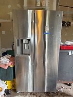 Full front view of LG side by side refrigerator freezer with stainless steel finish and ice/water dispenser on left door.