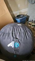 Gray oversized bean bag chair with visible LoveSac label attached to the cover, showing the size and fabric condition.
