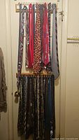 Two vertical racks filled with various men's neckties displaying multiple colorful patterns and designs like tools, candy corn, and holiday themes.