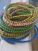 Photo showing multiple braided and solid color halter ropes coiled together, used for calves or sheep.