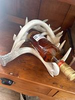 Decorative fake antler wine rack holding a wine bottle showing overall use and appearance