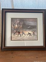 Framed print showing children playing hockey in winter with barn in background