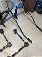 Photo showing two hockey stick-shaped plastic frames holding hockey sticks, placed on a concrete floor.