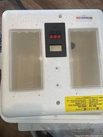 Top view of the Little Giant styrofoam incubator showing two rectangular clear viewing windows and a central black control panel with three red buttons and a digital display.