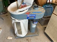 Front view of King Canada dust collector, showing dust bag, motor housing and base.