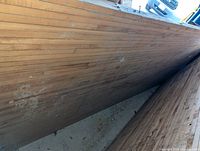 Photo showing top surface and grain of maple wood bowling lane board, surface has some wear marks.