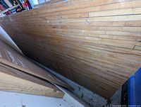 Angled view of maple lane surface showing laminated strips and wear marks