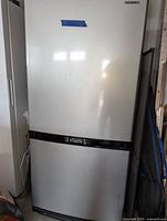 Full exterior view showing stainless steel finish, upper refrigerator door and lower freezer drawer