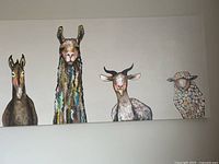 Full view of the large canvas wall art with four whimsical animal paintings including a horse, colorful llama, goat, and sheep.