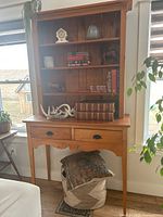 Two-piece solid pine wall cabinet with upper shelving and lower drawers, showing front view with displayed antique items (not included).