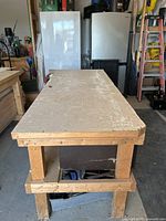 Angled side view of workshop bench showing solid wood top and robust wooden leg frame