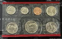 Front view of sealed 7 coin US set with silver and copper coins visible, including half dollar and quarter.