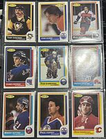 Full set of nine 1986-87 O-Pee-Chee NHL trading cards in protective sleeve, showing front sides with player portraits and team logos.