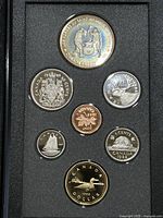 Seven Canadian coins from 1988 proof set arranged in original black foam display holder.