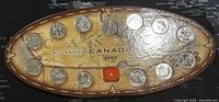 Front side of the Millennium Canada 1999 coin set showing 13 coins arranged on a themed map background.