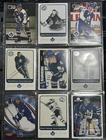 Front side of nine Toronto Maple Leafs hockey cards in plastic sleeve, showing players Todd Gill, Johnny Bower, Peter Zezel, Tim Horton, Wendel Clark, Darryl Sutter, Borje Salming and others.