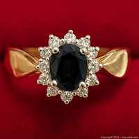 Front view of ring showing sapphire center and diamond halo