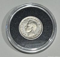 Front of 1940 Canada silver dime featuring King George VI in protective capsule, showing circulation wear but clear inscriptions.