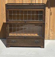 Front overall view showing two stacked sections with leaded glass panels and lower drawer