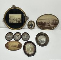 Photo showing the full set of nine antique framed photographs and pictures arranged on a white surface, depicting the variety in size and frame ornamentation.