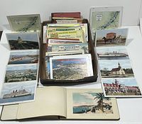 Overview of souvenir postcard sets, with various fold-out cards featuring ships, buildings, and natural landscapes around Fredericton and other locales.