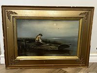 Full view of the antique framed painting showing woman sitting in a wooden rowboat beside a dock, framed in a large gold-colored frame with decorative corners.