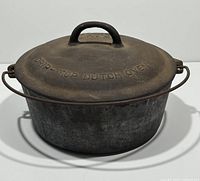 Front view of the vintage McClary No. 8 cast iron Dutch oven with drip-top lid and wire handle.
