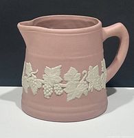 Front and side views of vintage pink pitcher with white grapevine relief